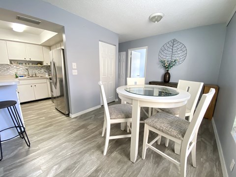 a dining room with a table and chairs and a kitchen