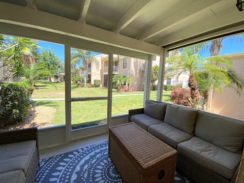 a screened in porch with a couch and a coffee table