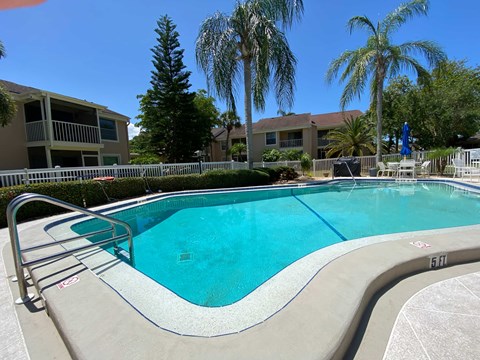 a swimming pool at a hotel with palm trees