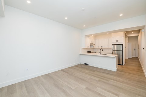 A kitchen with white cabinets and a wooden floor.