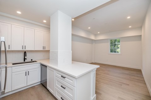 A kitchen with white cabinets and a window.
