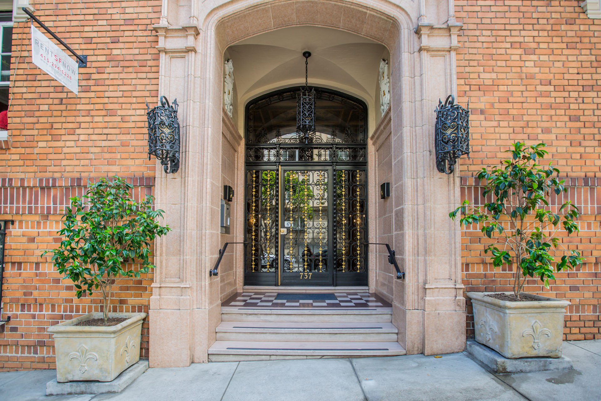 A building with a glass door flanked by two planters.