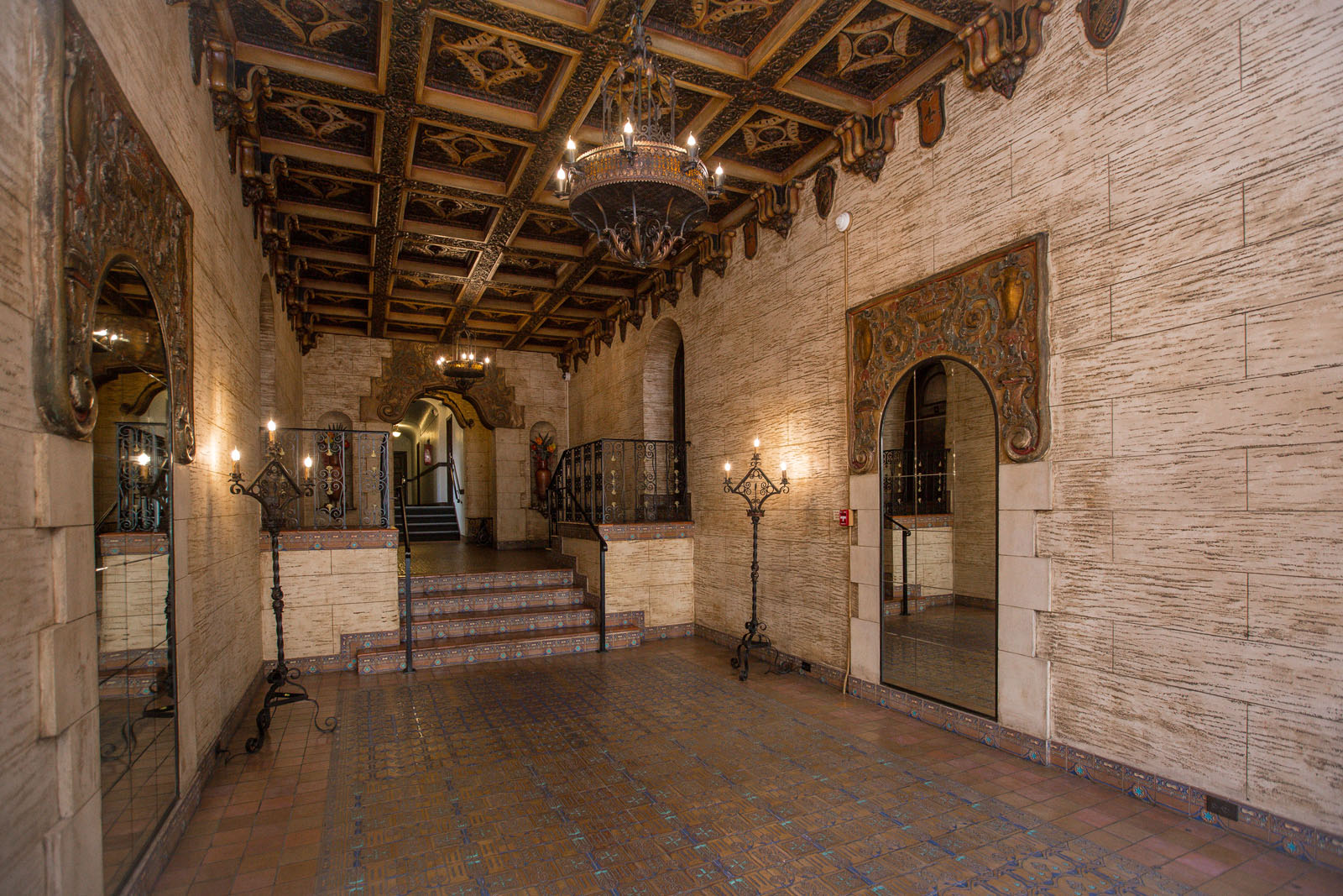 A hallway with a brick floor and a wooden ceiling.