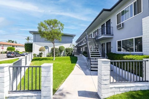 a house with stairs and a sidewalk in front of it