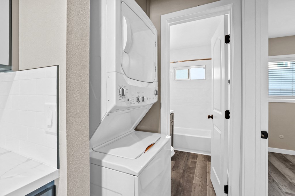 the laundry room has a washer and dryer and a door to the bathroom
