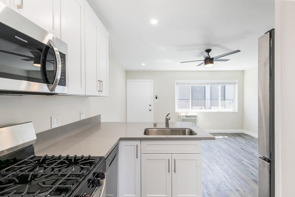 a kitchen with white cabinets and a stove and a sink