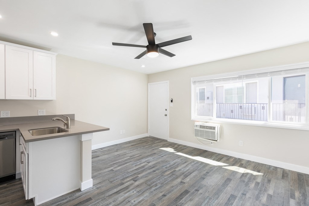 an empty kitchen and living room with a ceiling fan