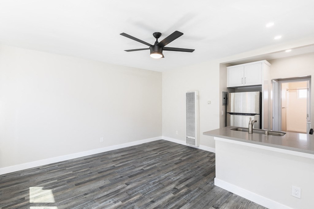 a living room with a ceiling fan and a kitchen