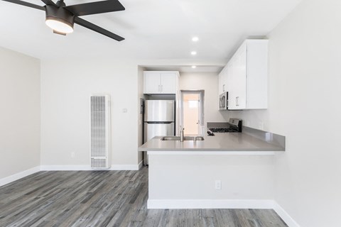 a renovated kitchen with white cabinets and a stainless steel refrigerator