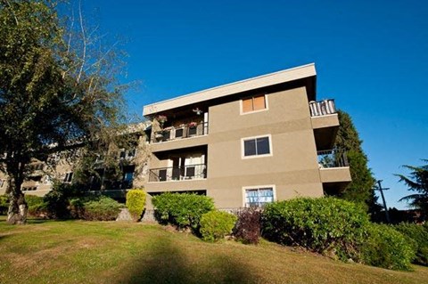 A beige building with a balcony on the second floor.