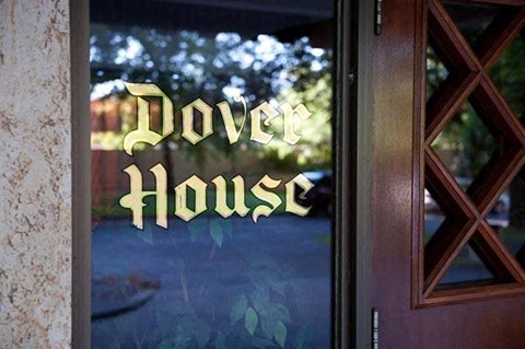 A glass door with the word Dove House written on it.