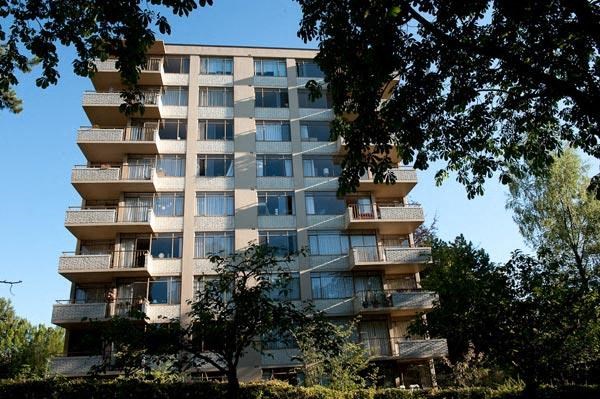 A tall residential building with balconies on each floor.