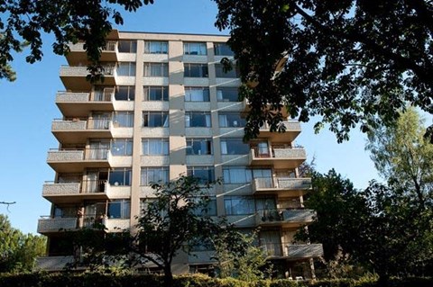 A tall residential building with balconies on each floor.