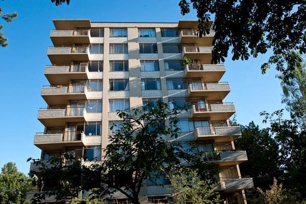 A tall apartment building with balconies on each floor.
