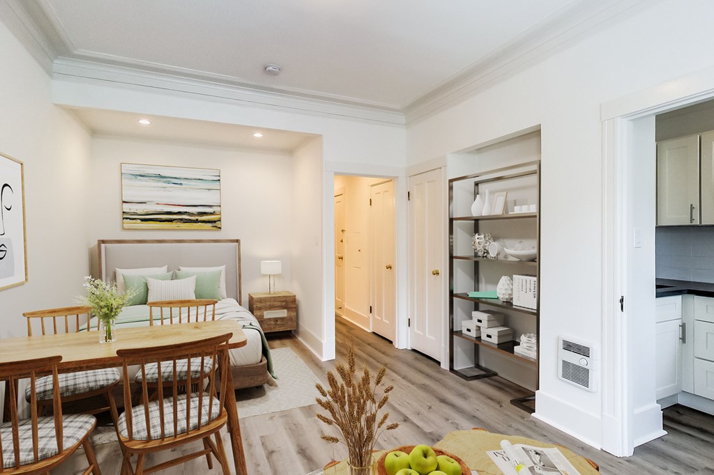 a living room with a bed and a table and chairs