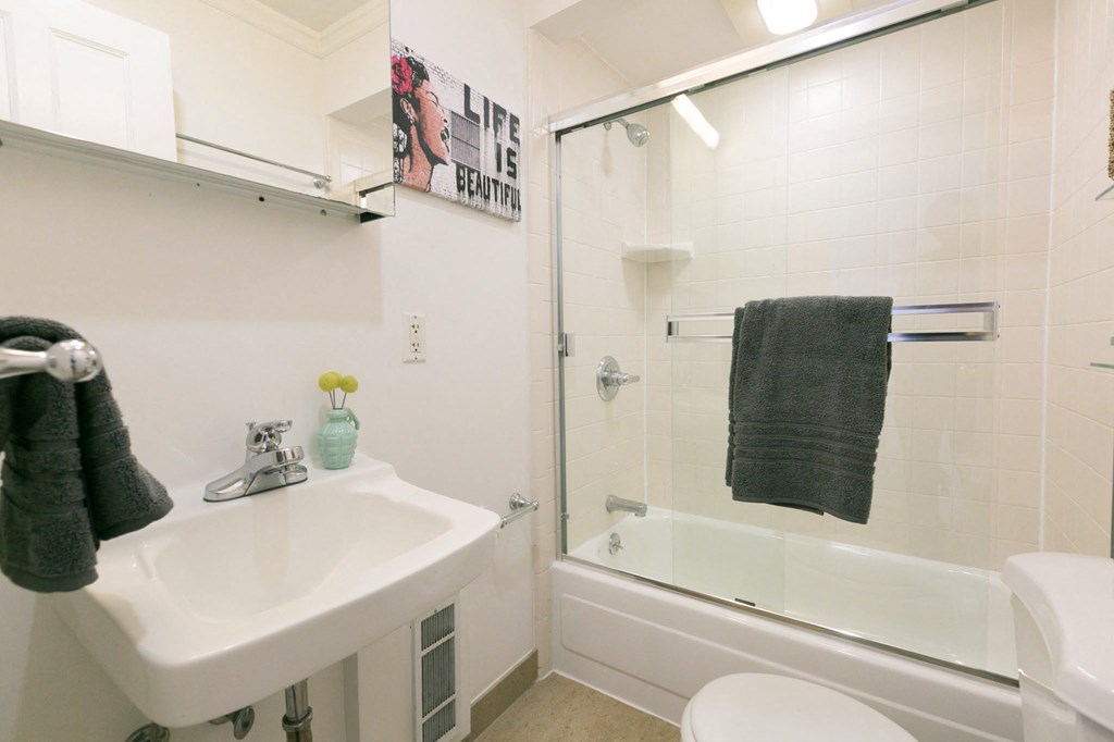 a white bathroom with a sink and a shower