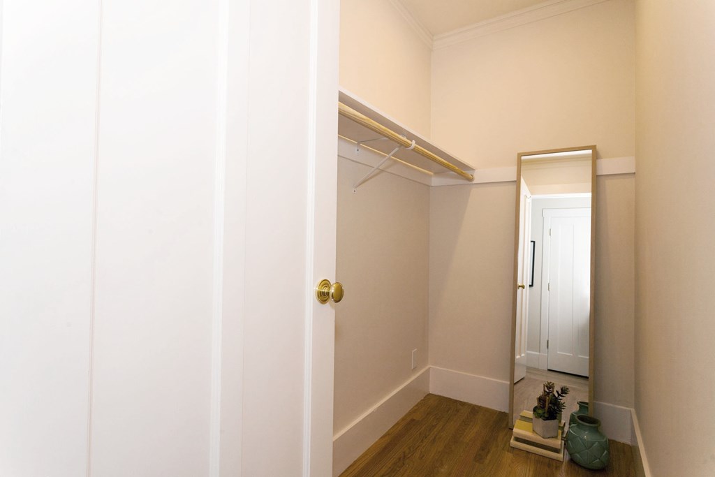 A white door with a gold handle is open to a hallway.