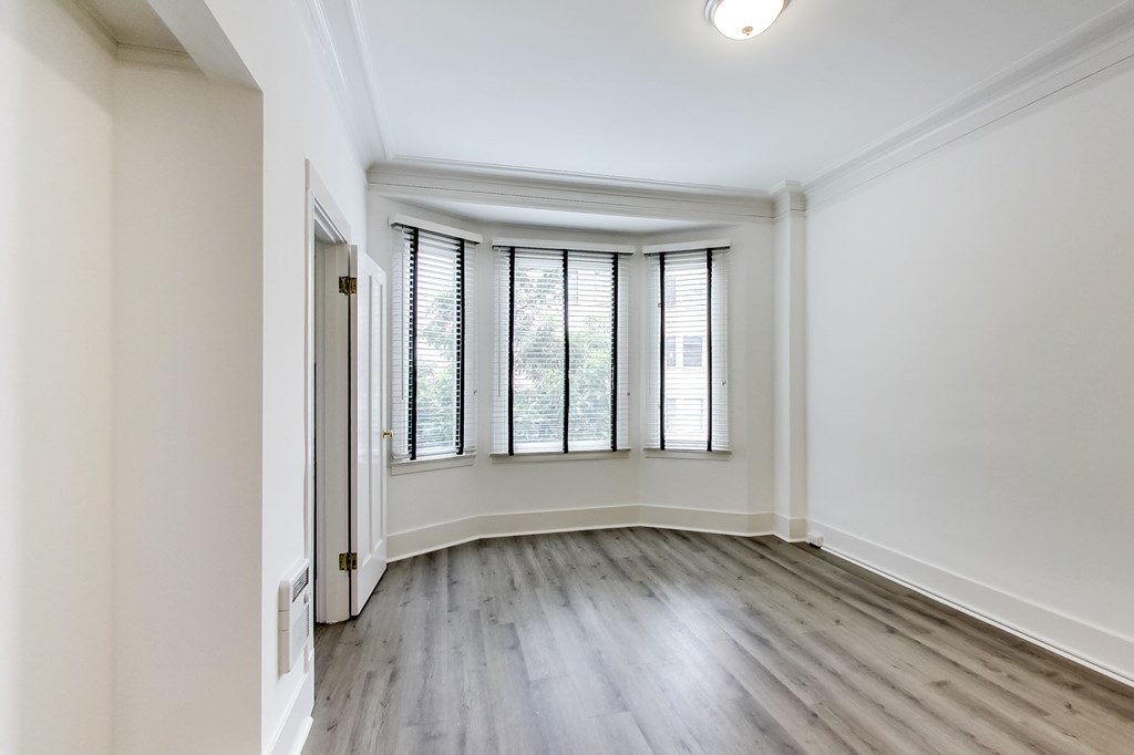 an empty living room with white walls and a window
