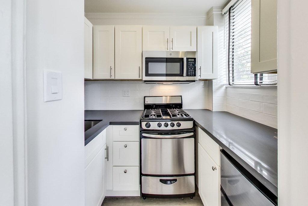 a kitchen with stainless steel appliances and white cabinets