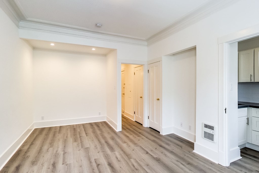 a living room with white walls and wood floors