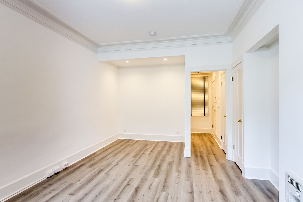 a living room with white walls and wood floors
