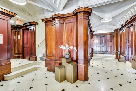 A hallway with wooden doors and a chandelier.