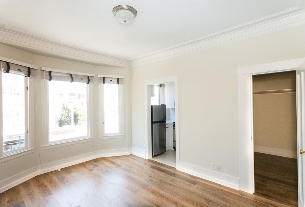 a living room with a hard wood floor and white walls