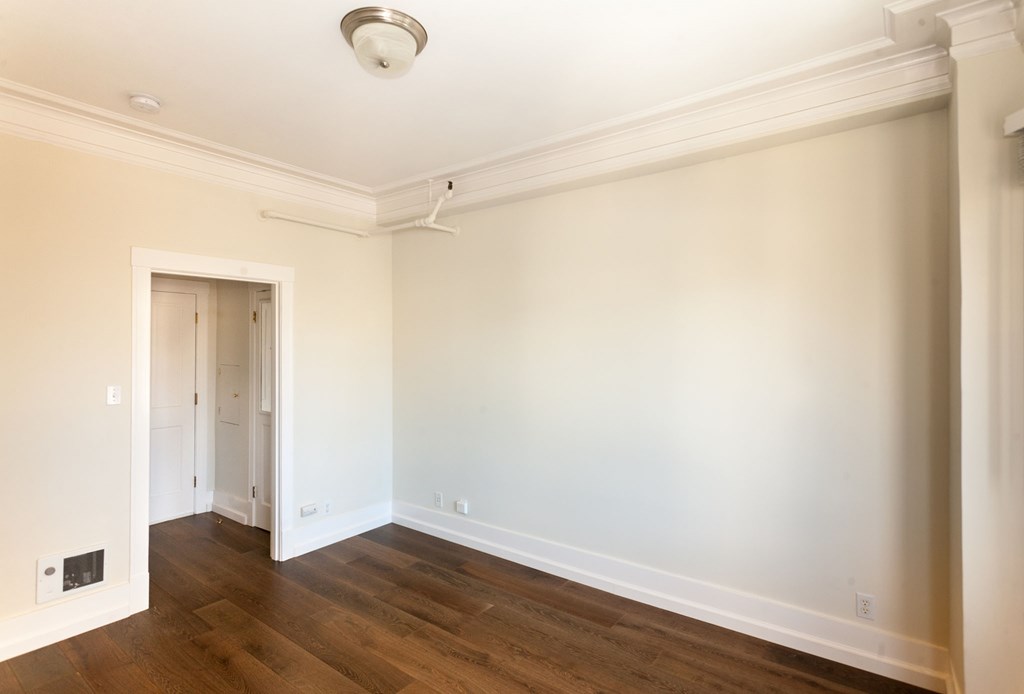 a living room with white walls and a wood floor