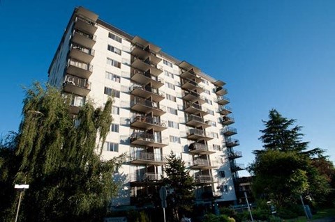 A tall residential building with balconies on each floor.