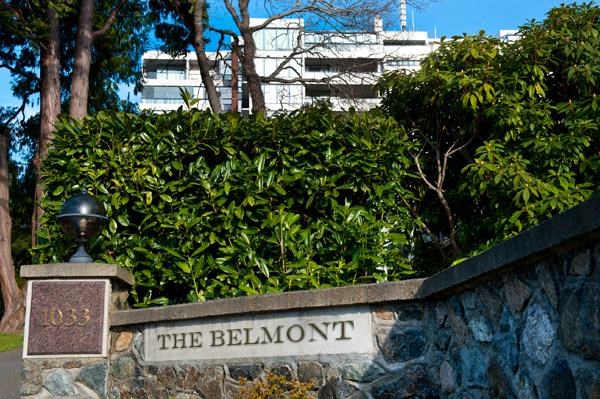 A sign that says "The Belmont" is on a stone wall.