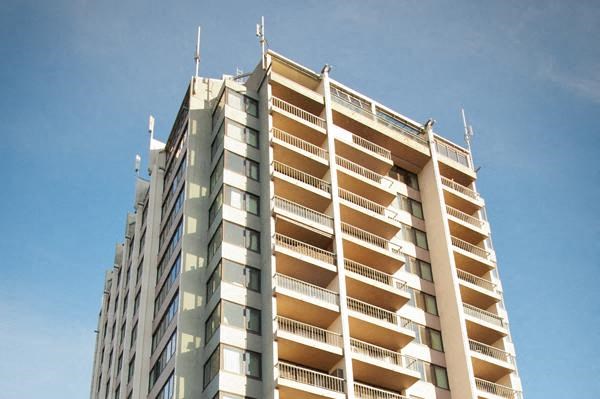 A tall building with balconies on each floor.