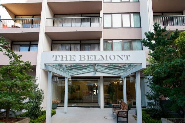 The Belmont is a multi-story residential building with a covered outdoor seating area.
