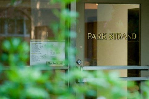 A glass door with a sign that says "No Pets" and "Park Strand".
