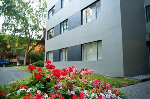 A building with a flower bed in front of it.