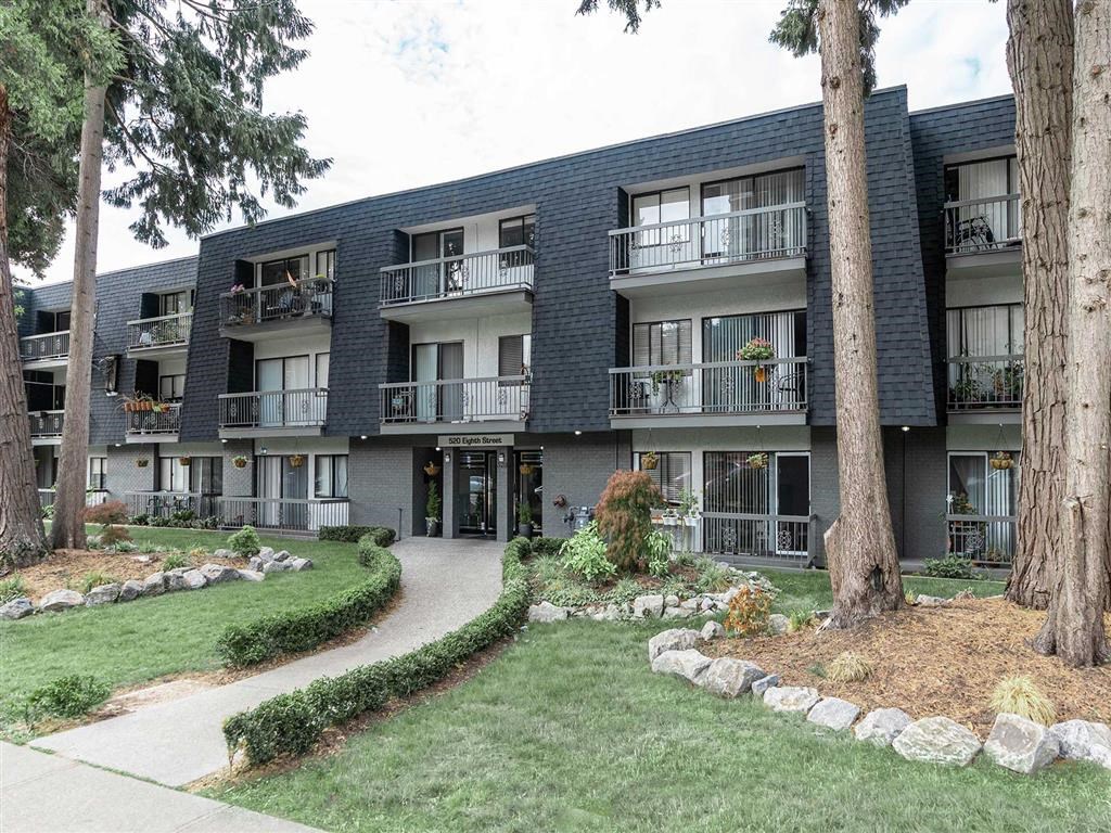 Apartment building with a green lawn in front.