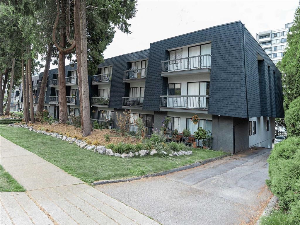 A black apartment building with a white door and windows.