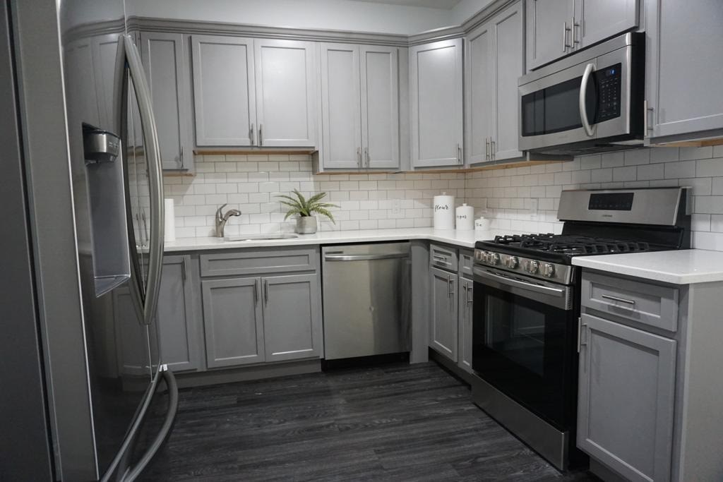 a white kitchen with stainless steel appliances and white cabinets