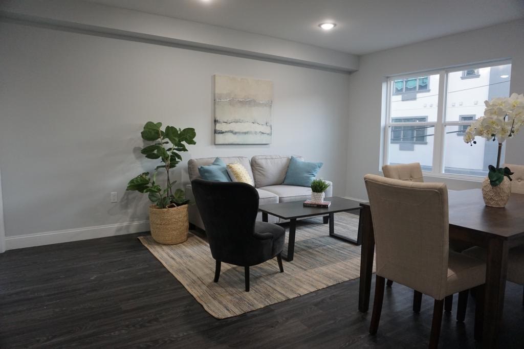 a living room and dining room with a table and chairs