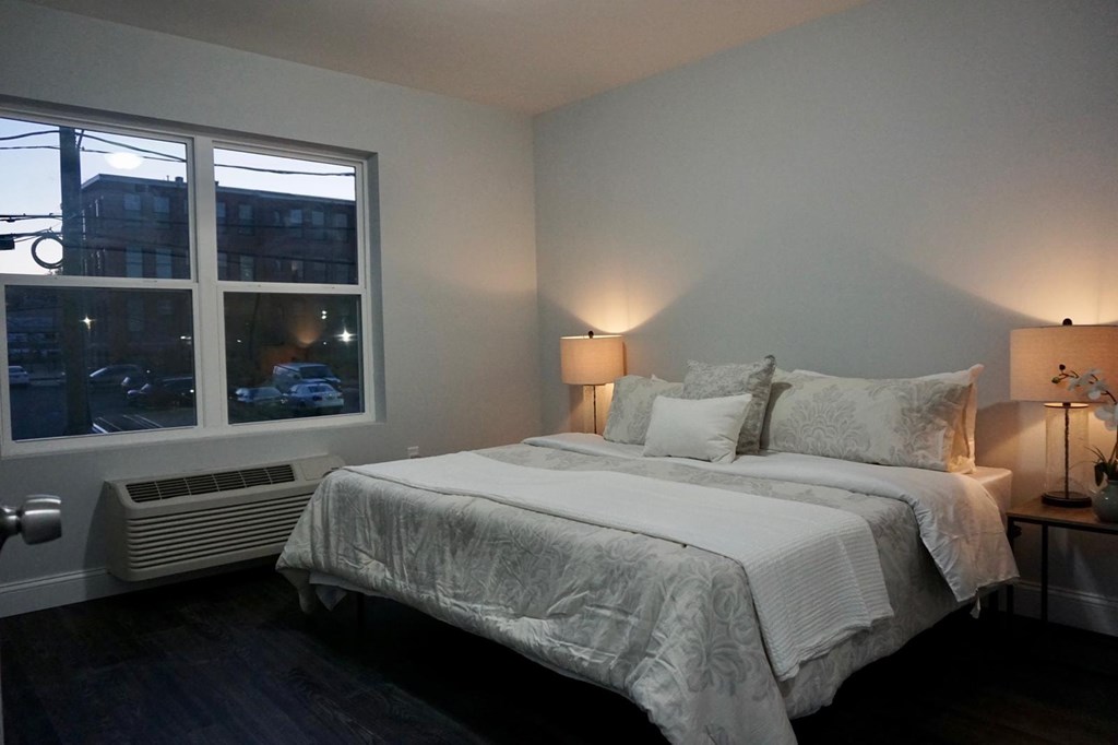 a bedroom with a bed and a large window