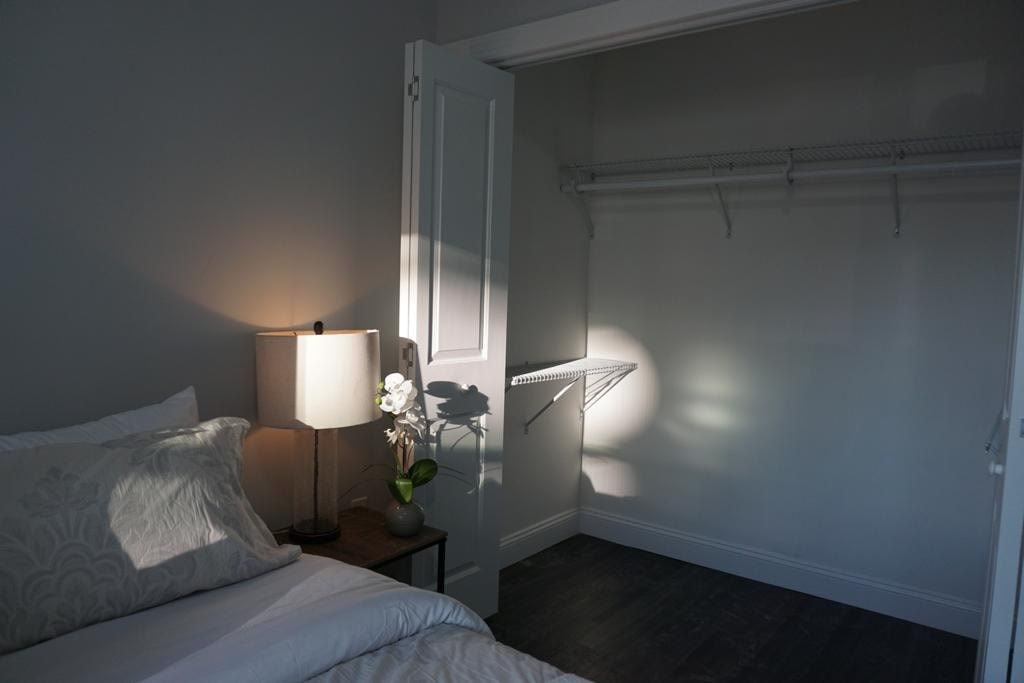 a bedroom with a bed and a lamp and a closet