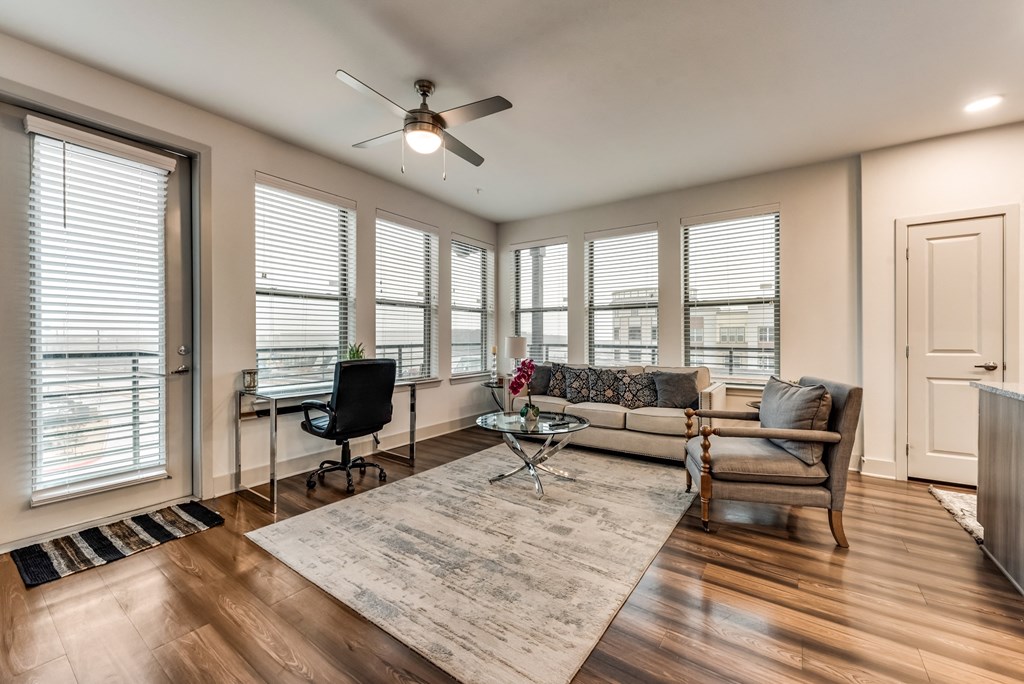 an open living room with a ceiling fan and windows