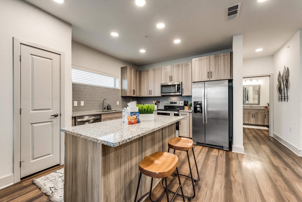 a kitchen with a large island with two stools