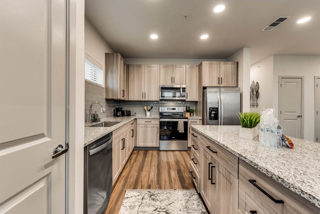a kitchen with wooden cabinets and granite counter tops