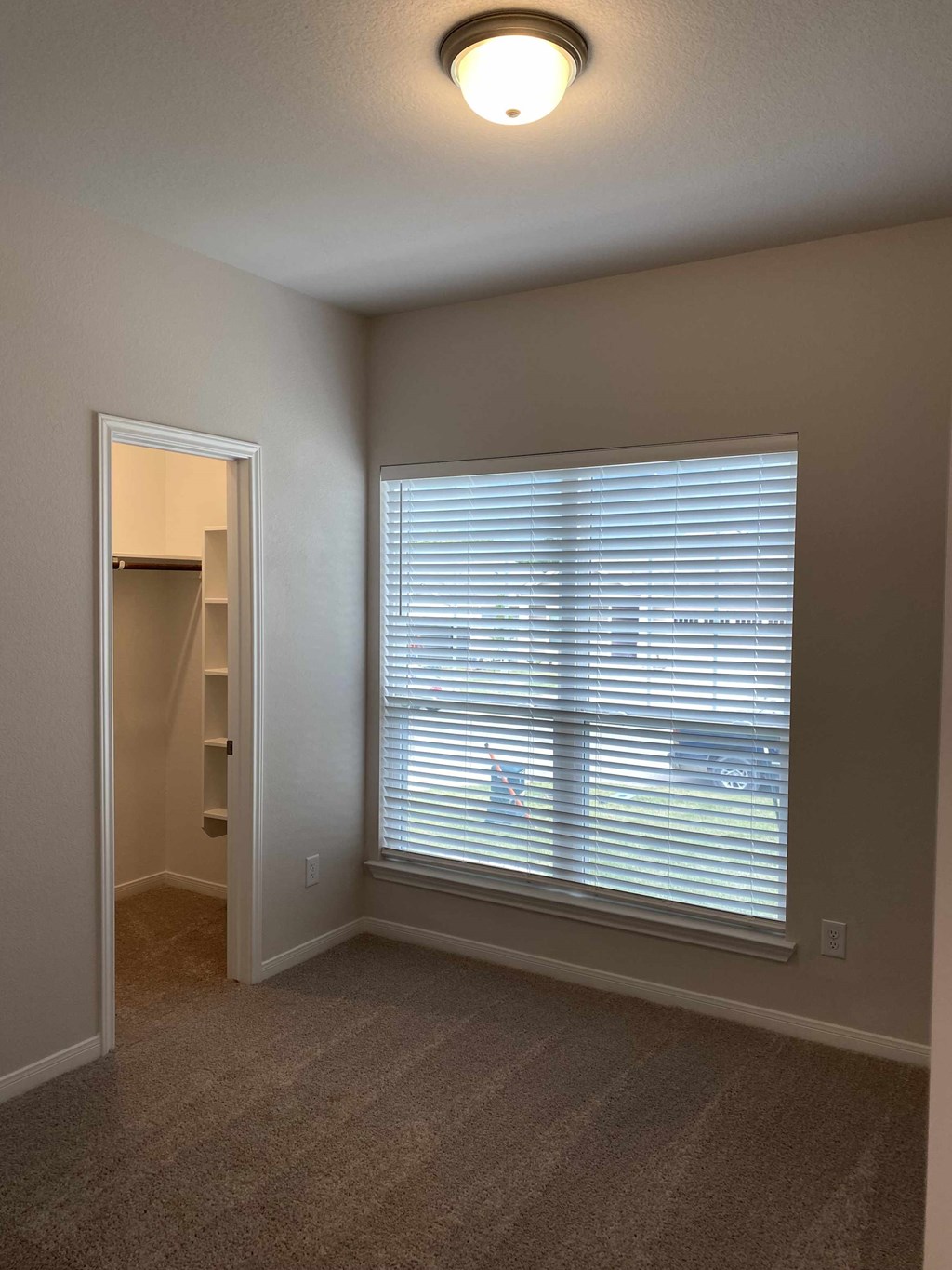 a living room with a large window and a door to a closet
