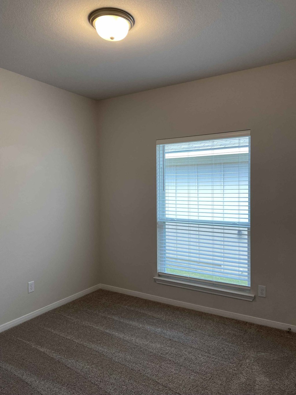 a bedroom with a large window and a carpet