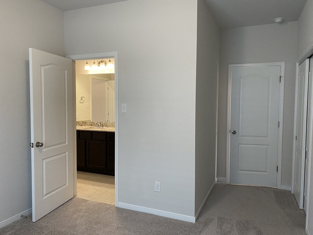 a bedroom with a closet and a door to a bathroom