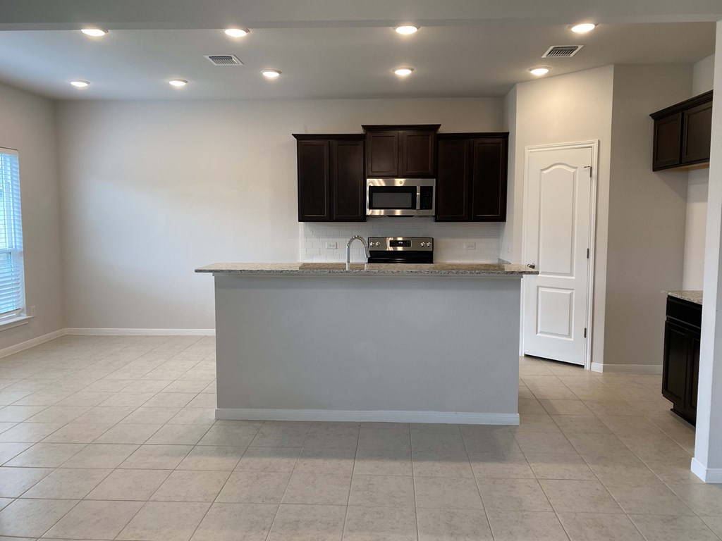 an empty kitchen with a counter top in a house