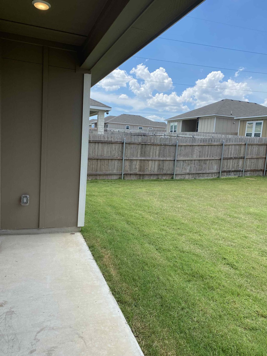 a backyard with a fence and a yard with grass