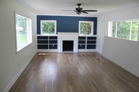 a living room with a hard wood floor and a fireplace