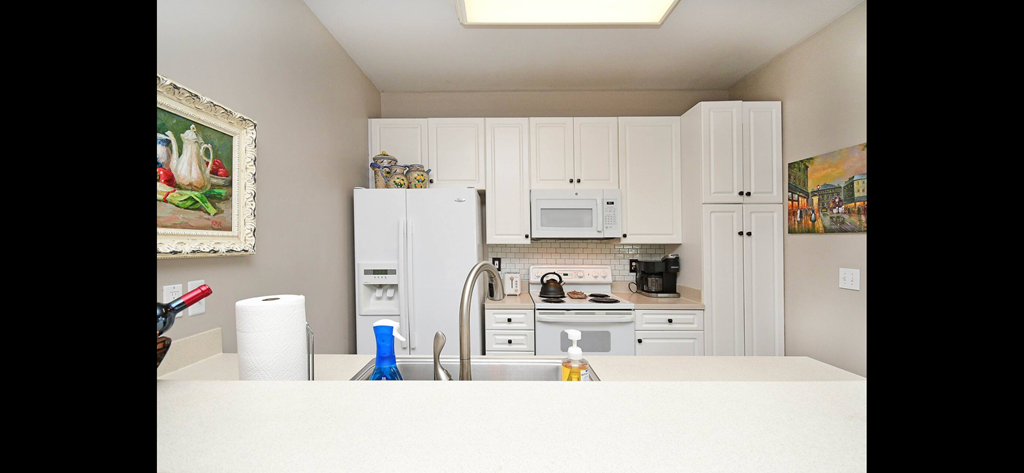 a kitchen with white cabinets and a sink